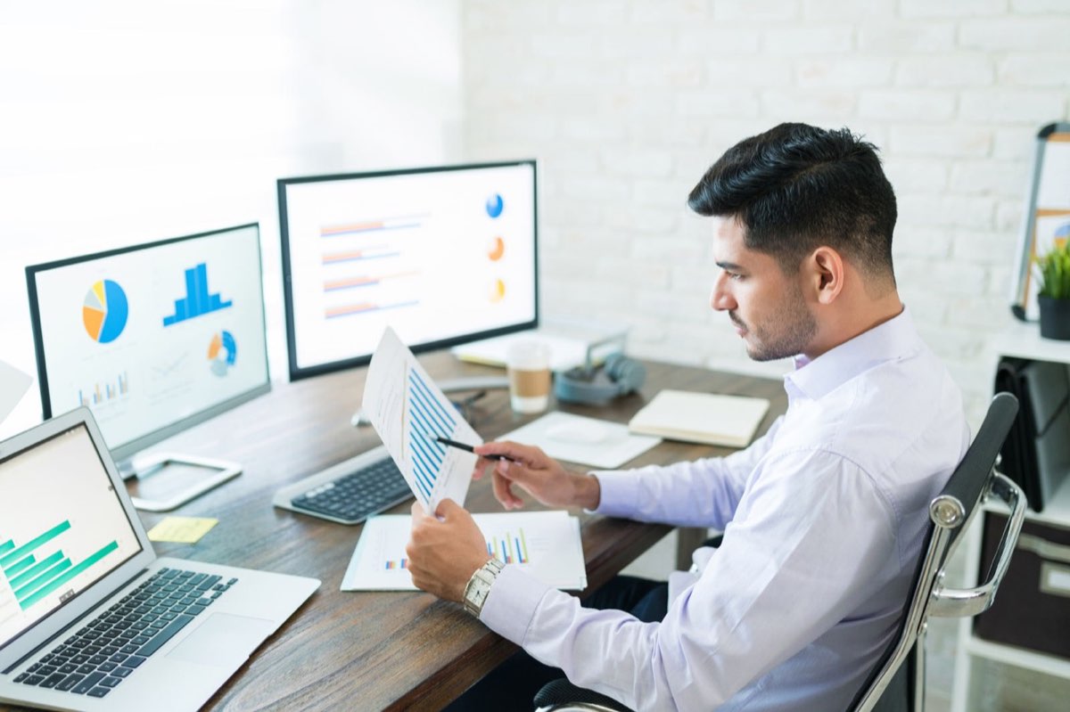 Analyst reviewing financial figures on two monitors